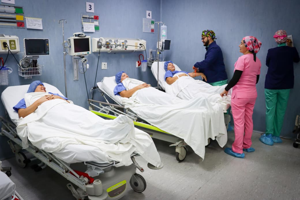 Pacientes en sus camillas y personal médico supervisándolas
