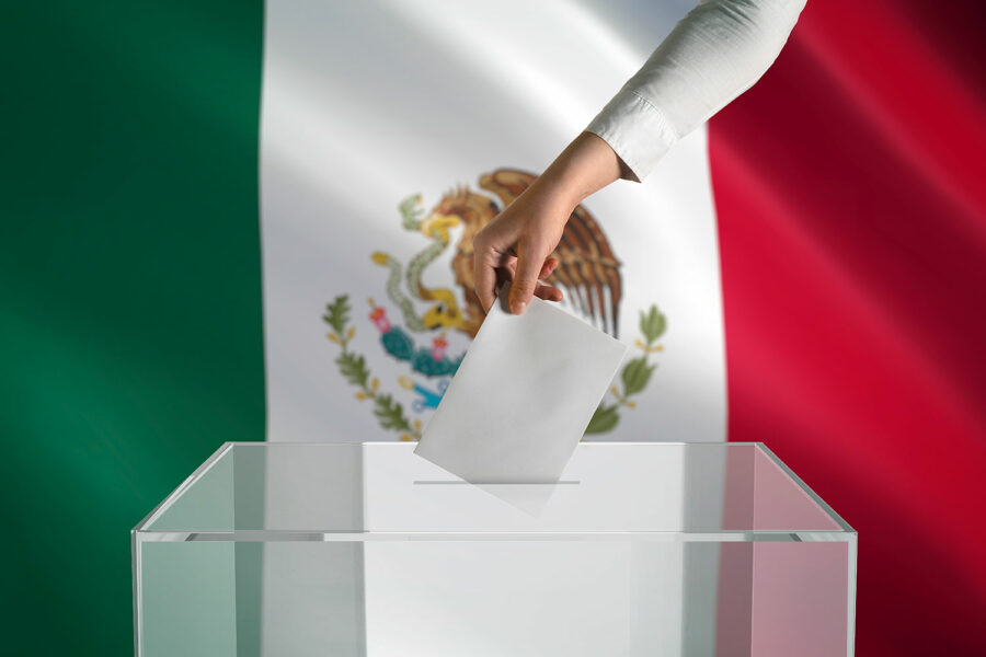 Bandera de México y el brazo de una persona introduciendo una hoja de papel a una urna