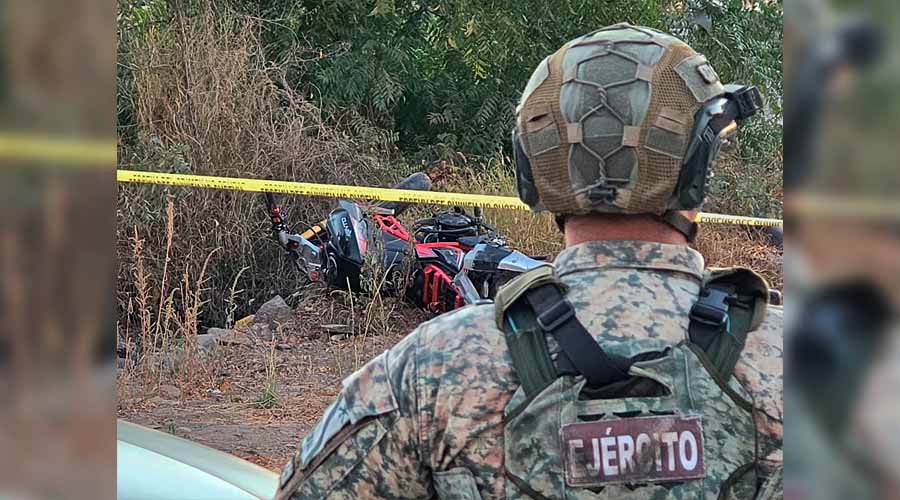 Elemento del ejército frente a una motocicleta involucrada en un atentado, en Culiacán