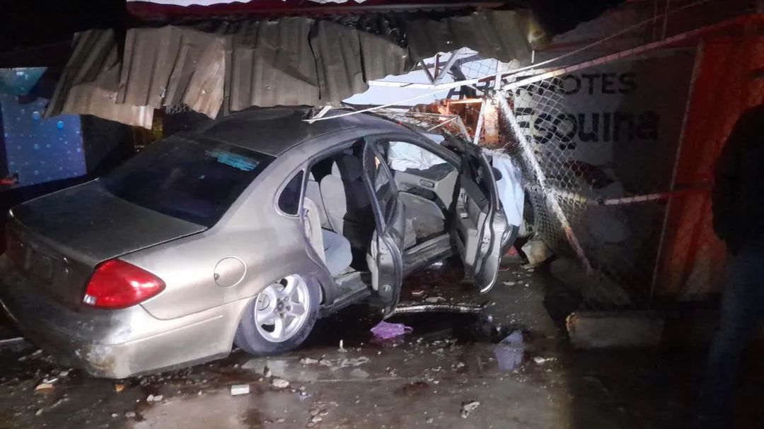 Carro de color gris con el frente destrozado tras chocar contra una tienda