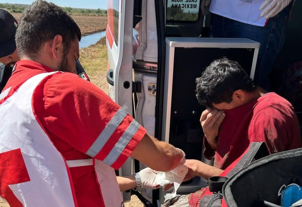 Un paramédico con una persona sentada agarrándose la cara