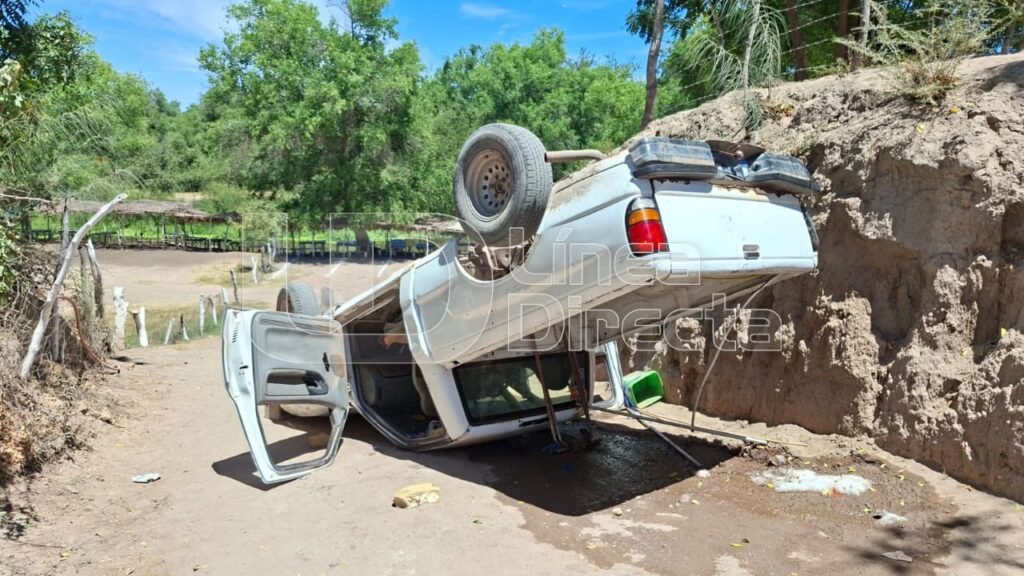 Parte trasera de camioneta blanca volcada con las puertas abiertas
