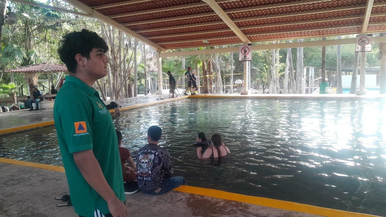 Personal de Protección Civil supervisando y gente dentro de una alberca