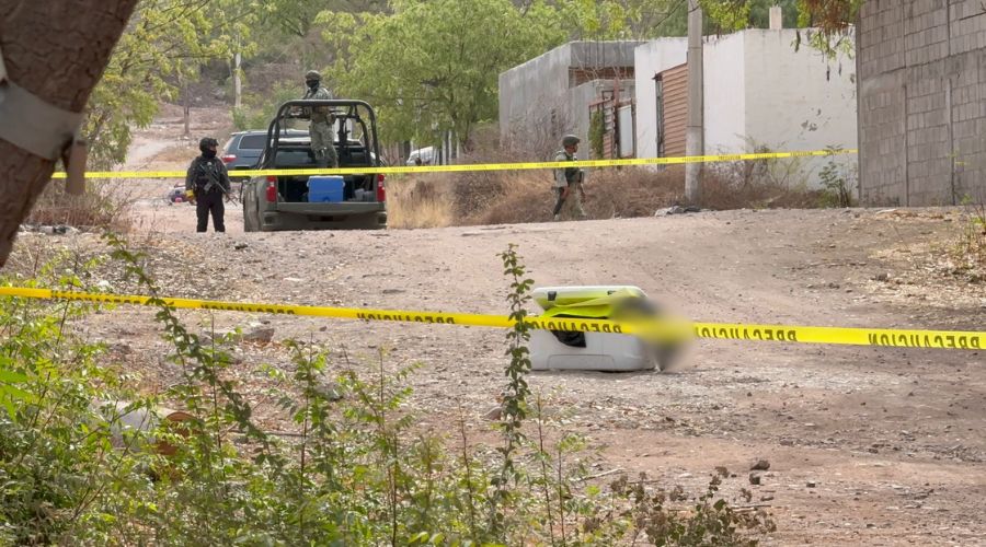 Zona asegurada con cinta amarilla, elementos de seguridad al fondo y una hielera en el medio de la zona