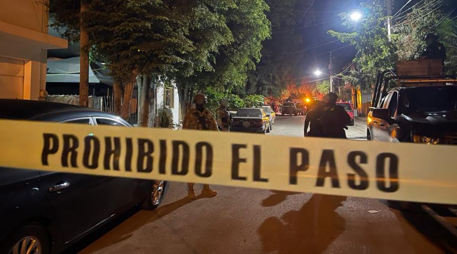 Unidad policiaca y elementos en una calle con una cinta amarilla de precaución