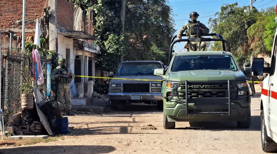 Unidad del Ejército Mexicano y Cruz Roja y militares en una calle de terracería en una colonia con una cinta amarilla de precaución