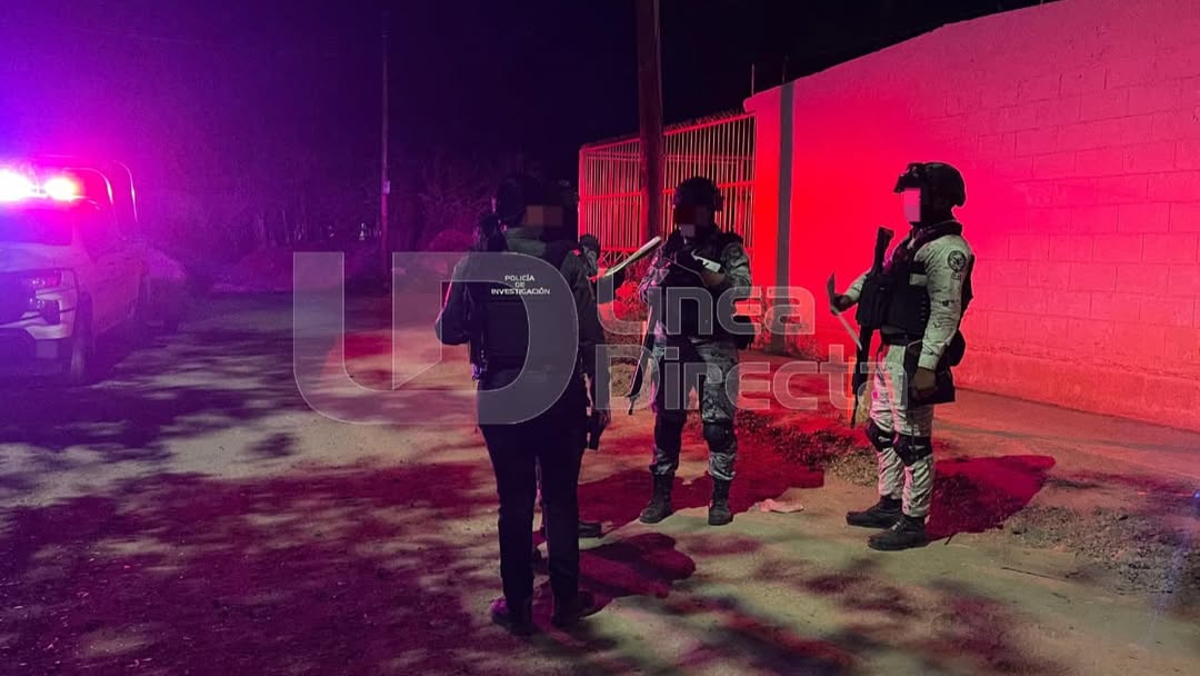 Agentes policiacos en una calle y unas luces de una patrulla encendidas
