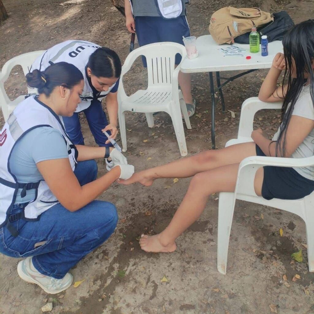 Personal de salud atiende a menor con una herida en el pie, en Guasave