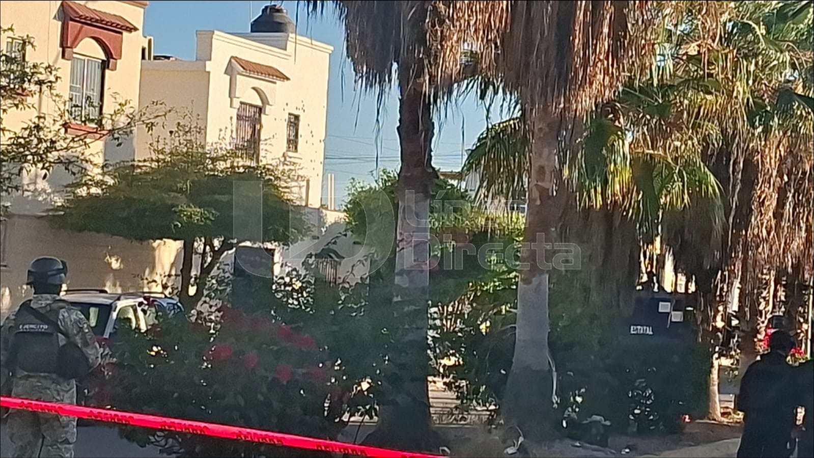 Casa con impactos de bala y elementos del ejército mexicano y una cinta de peligro color rojo