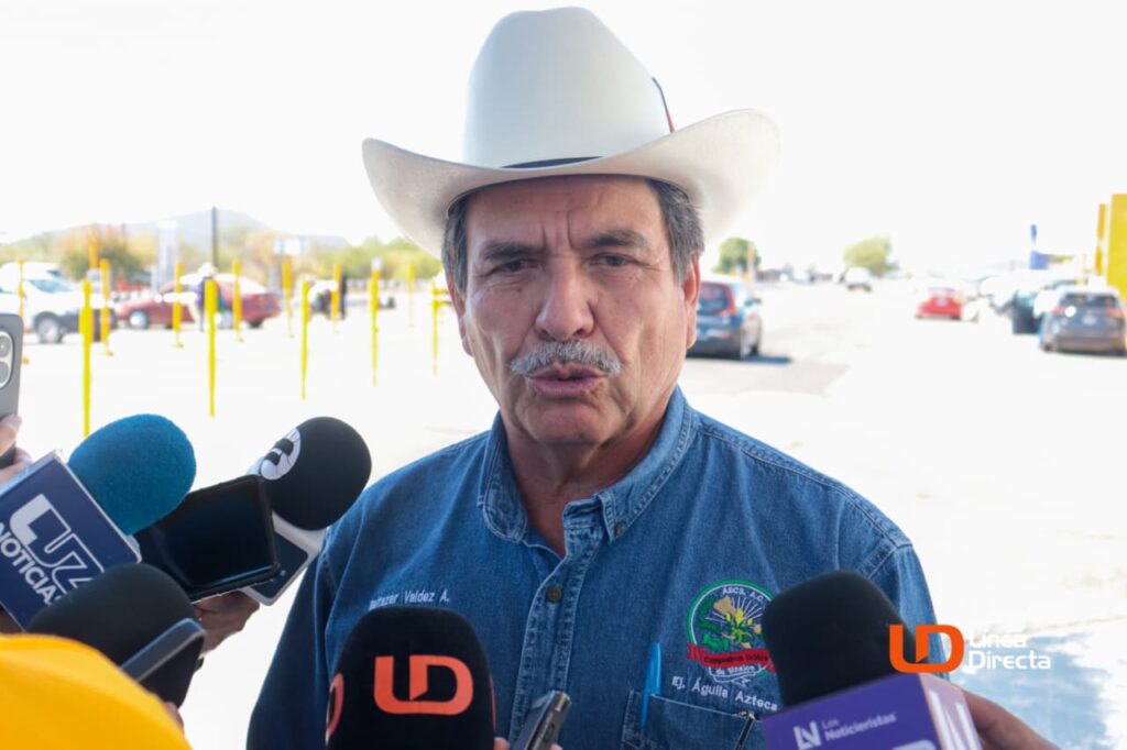 Hombre con sombrero hablando viendo hacia el frente con un micrófono adelante