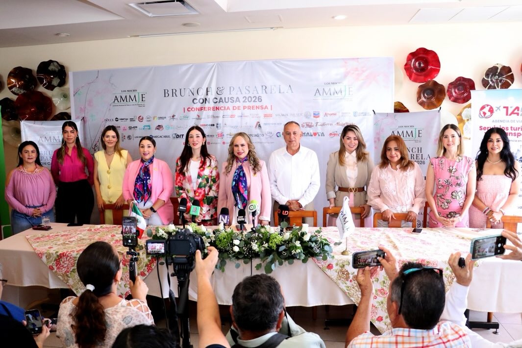 Personas paradas en una conferencia de prensa con micrófonos sobre una mesa