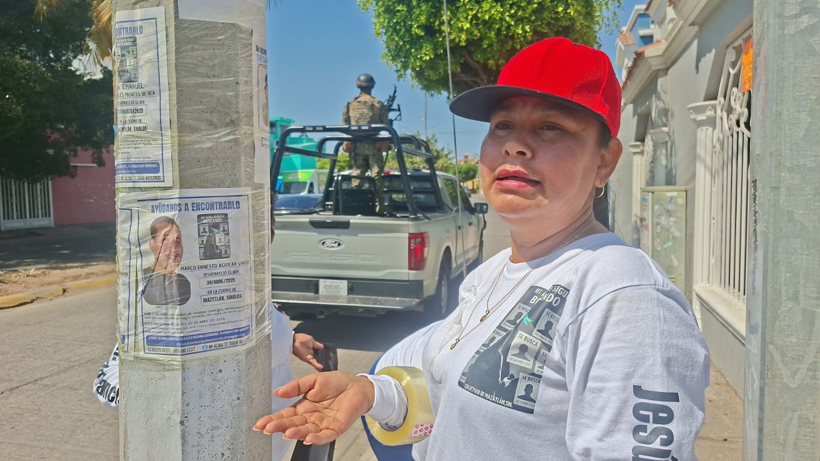 Integrante de colectivo de búsqueda colocando ficha en un poste