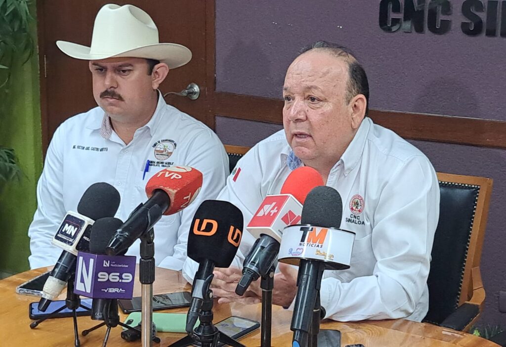 Dos personas sentadas con micrófonos en una mesa