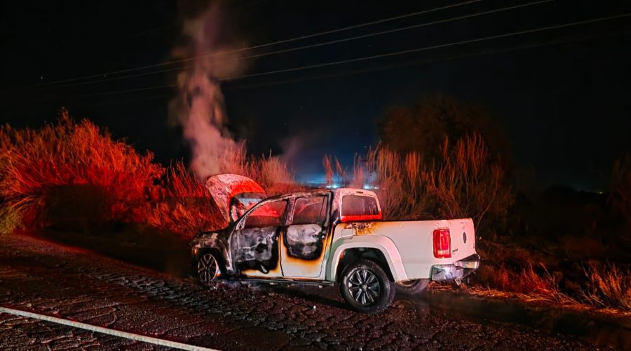 Camioneta de color blanco en una calle con humo saliendo por el fuego
