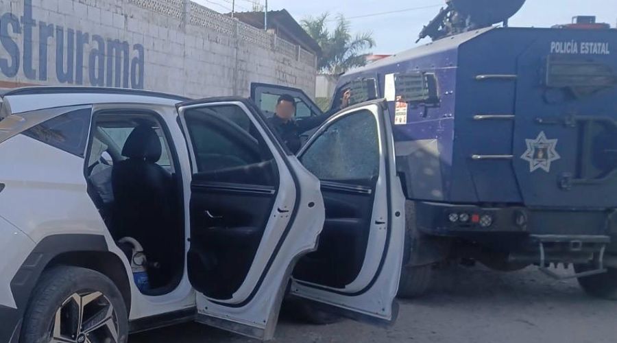 Vehículo blanco con las puertas abiertas y chocado contra una unidad de policía