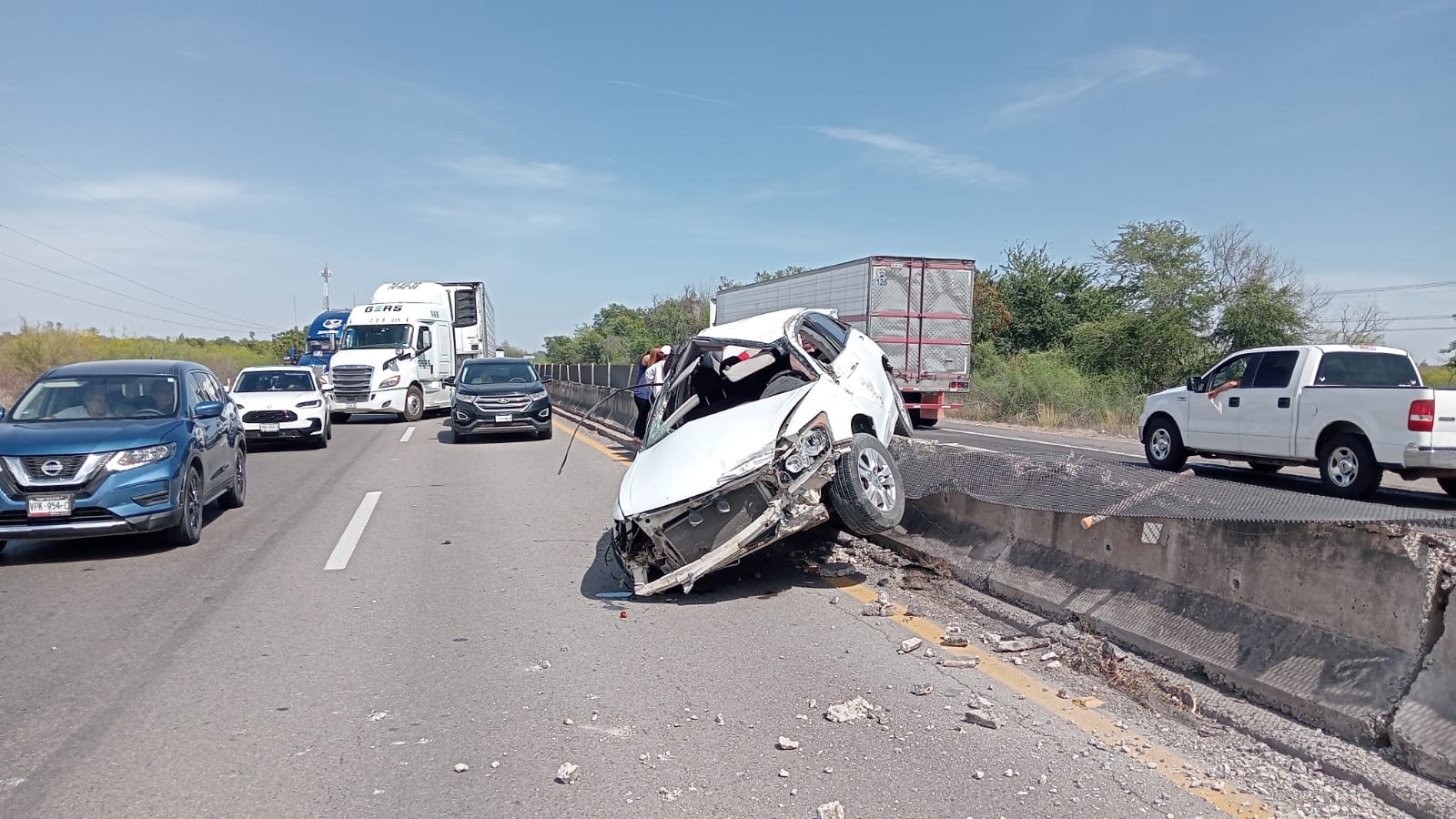 Carro blanco chocado contra el muro de contención