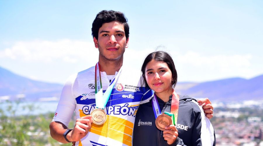 Dos atletas sosteniendo sus medallas posando para la foto