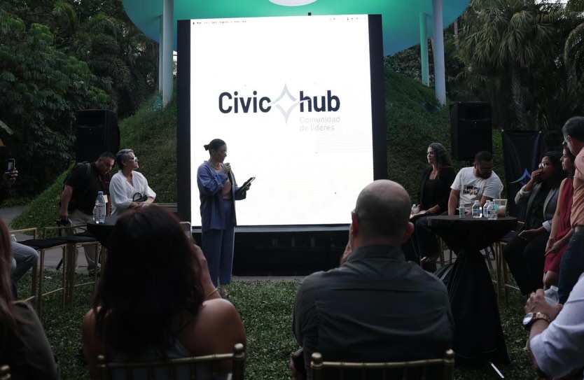 Personas dentro de una sala viendo una presentación