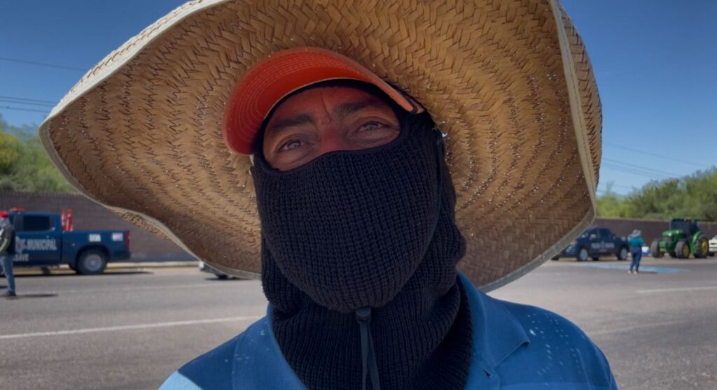 persona con cara cubierta y sombrero