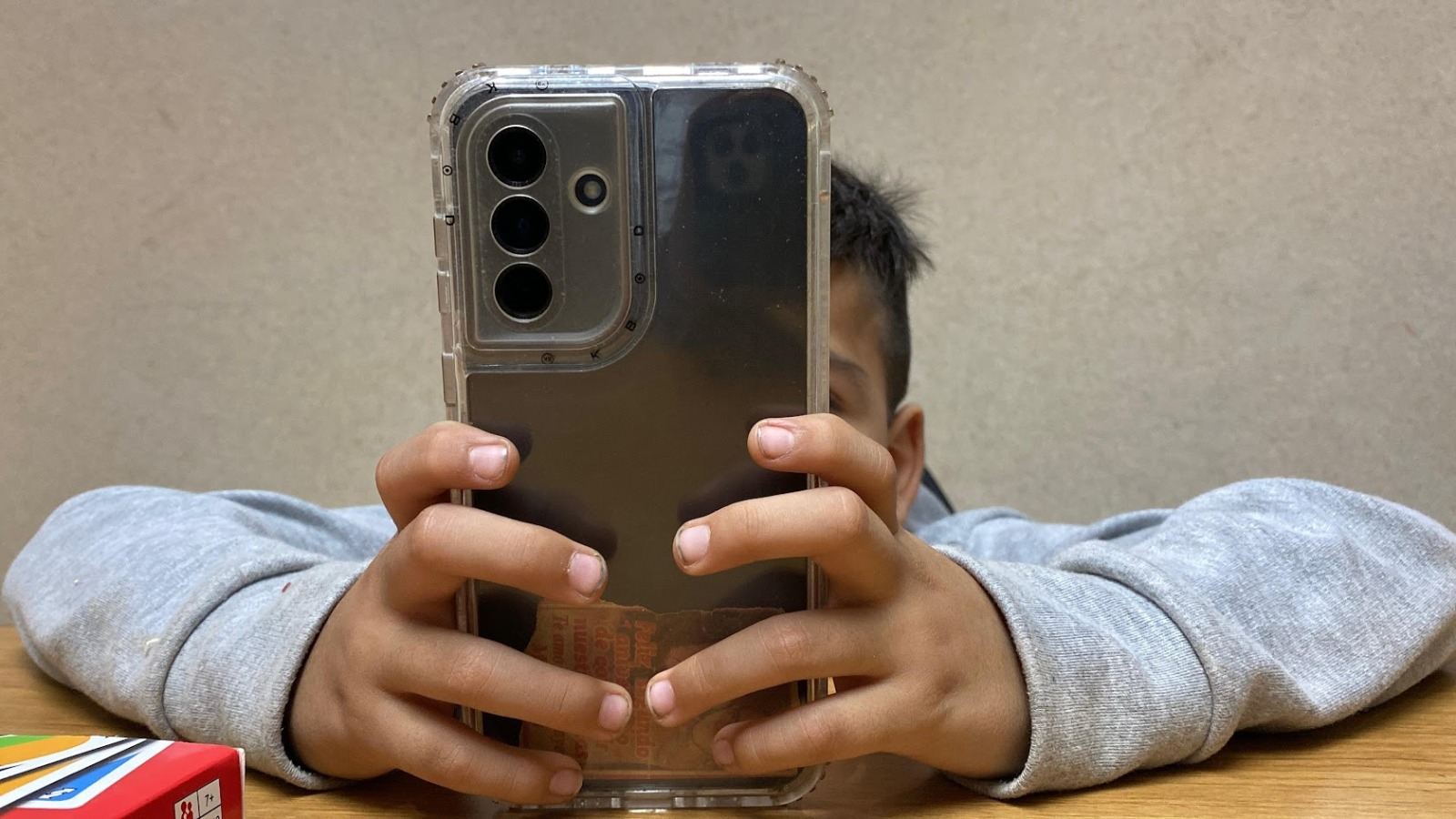 Niño con un celular agarrado con sus dos manos