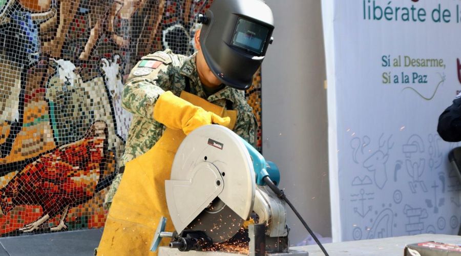 Personal del ejercito destruyendo un arma con maquinaria