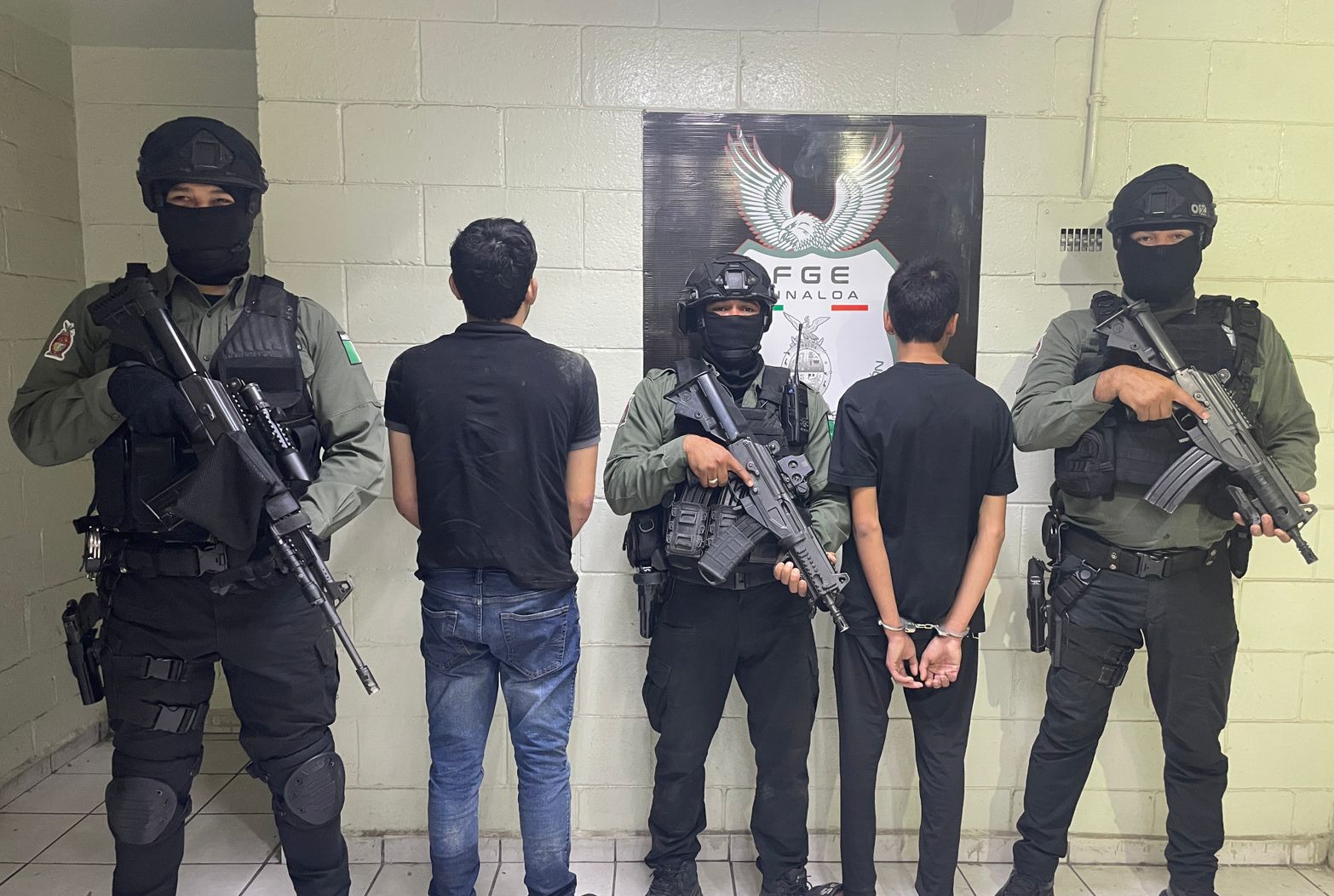 Agentes de seguridad custodiando a dos detenidos
