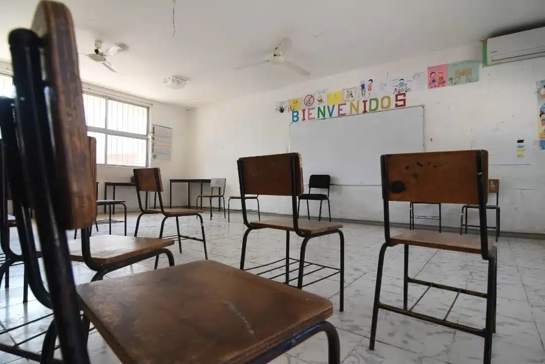Sillas en un salón de sales vacío con un pizarrón enfrente