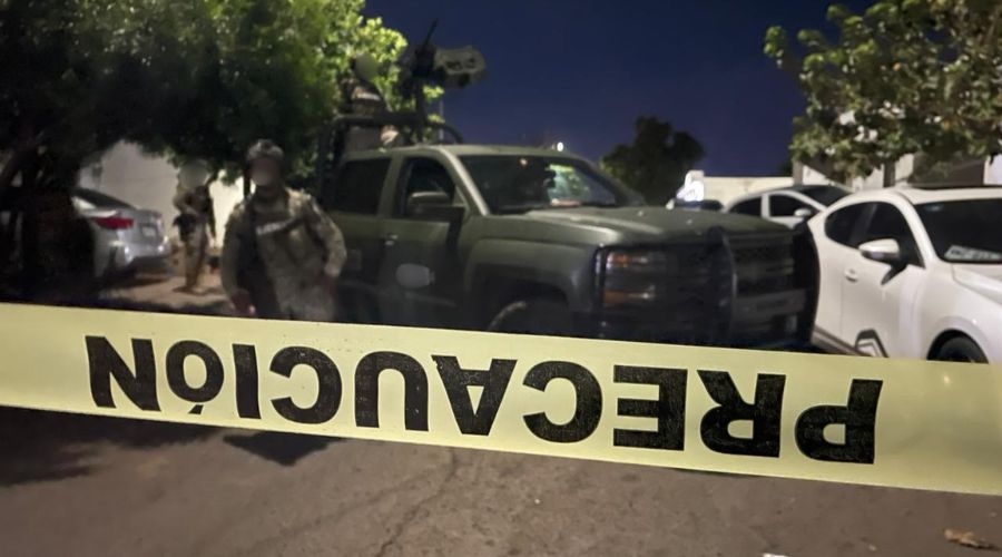 Unidad y elementos del Ejército Mexicano en una calle con una cinta amarilla de precaución