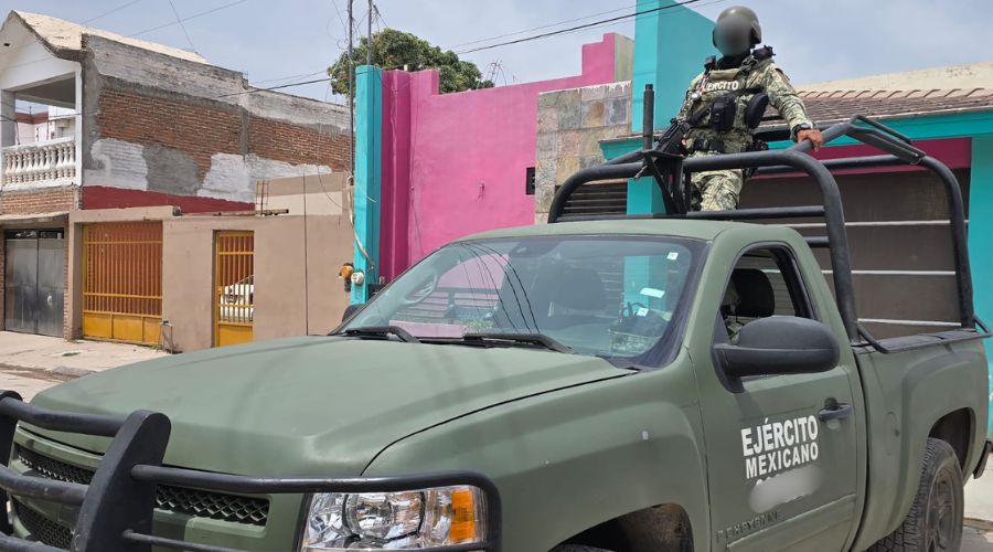 Unidad y elemento del Ejército Mexicano en una calle y casas al fondo