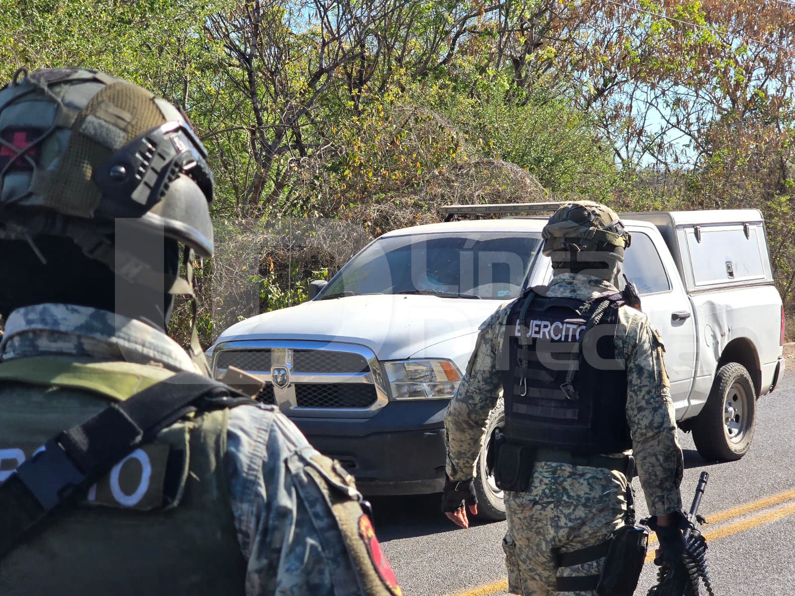 Elementos del Ejército Mexicano en una xona y al fondo una unidad del Semefo