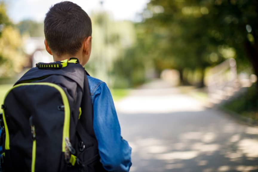 Niño estudiante dirigiéndose a la escuela.