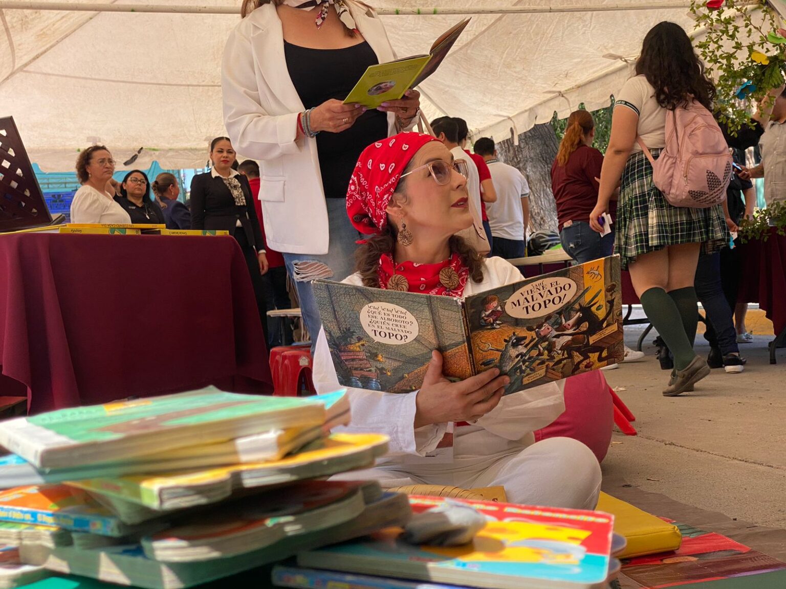 Persona leyendo con libros sentada