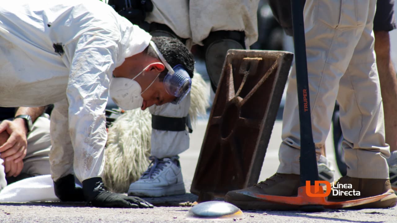 Persona con traje de plástico blanco y una alcantarilla de Los Mochis