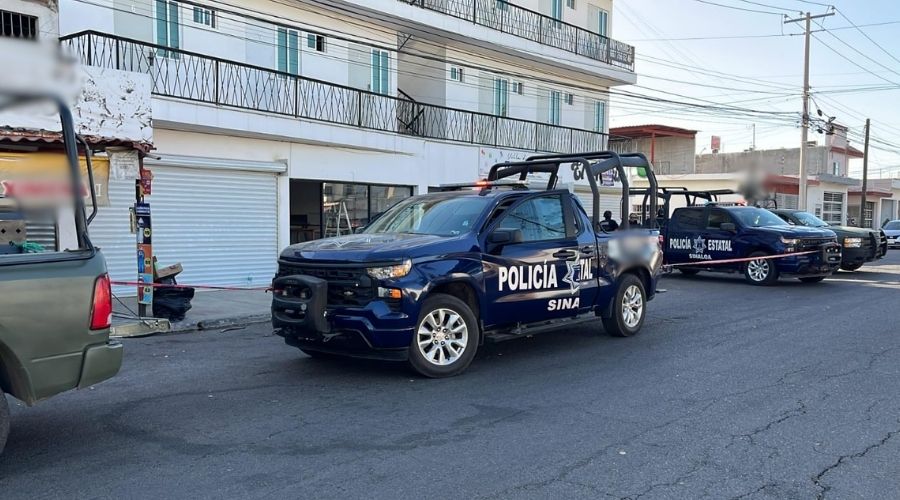 Tres unidades de la policía estatal frente un edificio blanco con barandal de metal negro