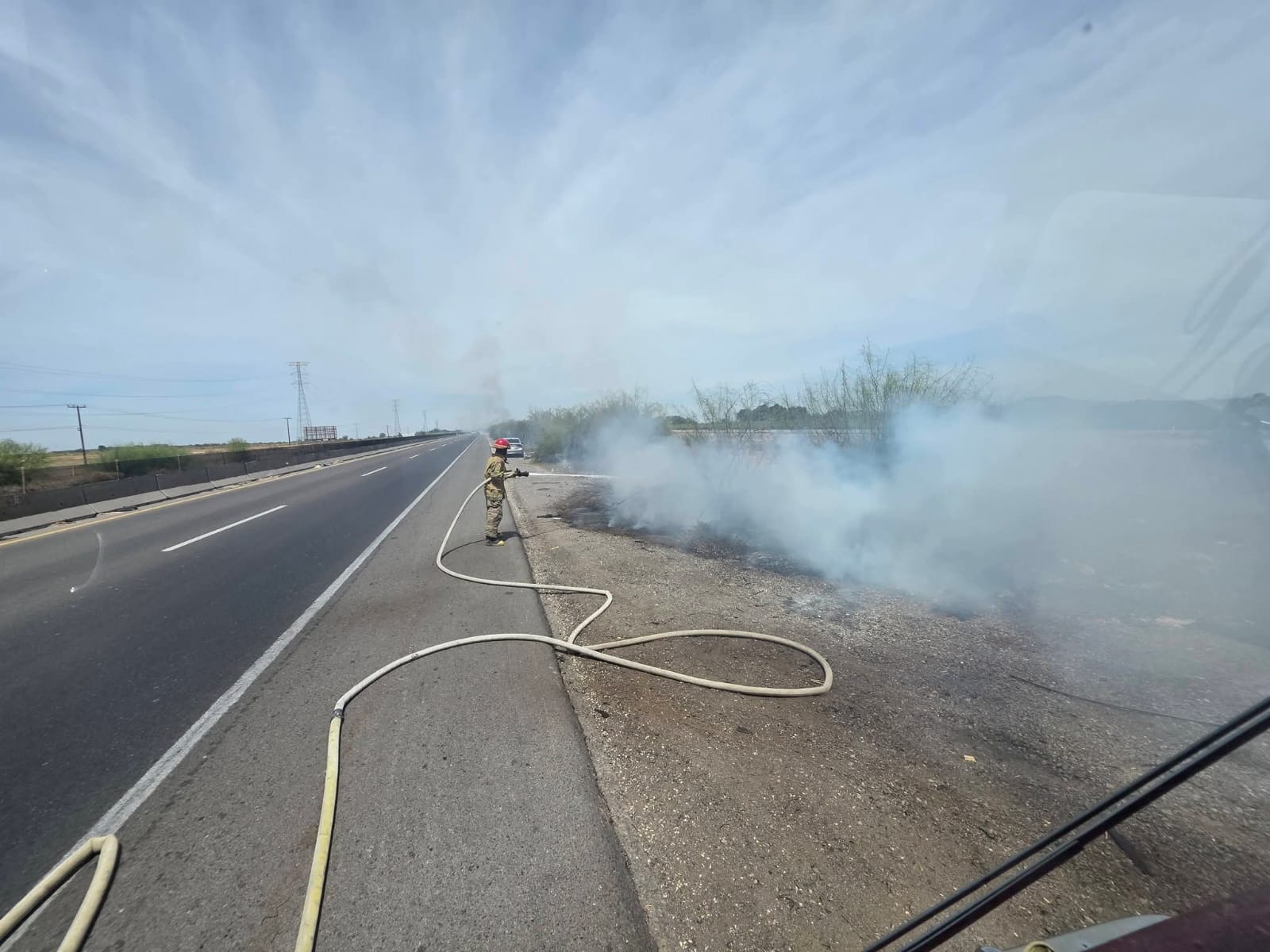 Bombero con una manguera apagando un fuego