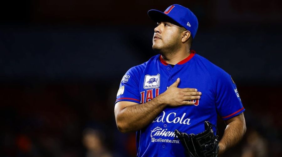 Jugador de beisbol mirando hacía un costado y tocandose el pecho