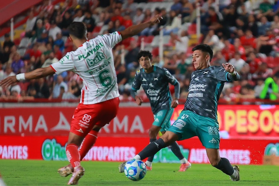 Dos jugadores de futbol disputando un balón dividido
