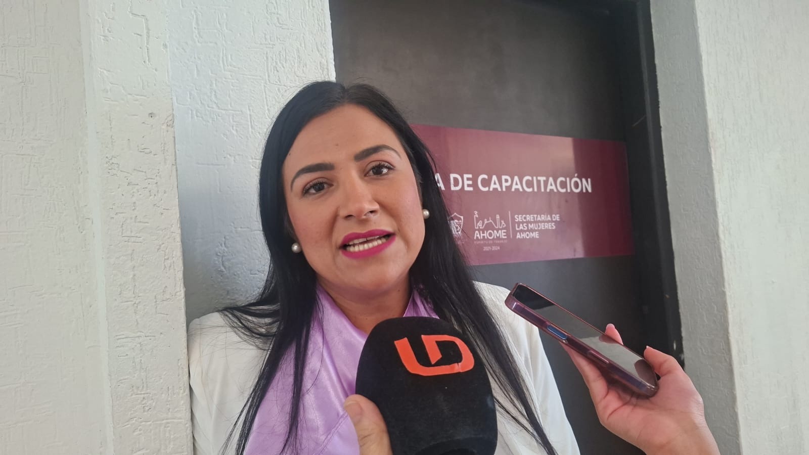 Mujer hablando hacia el frente con un micrófono negro