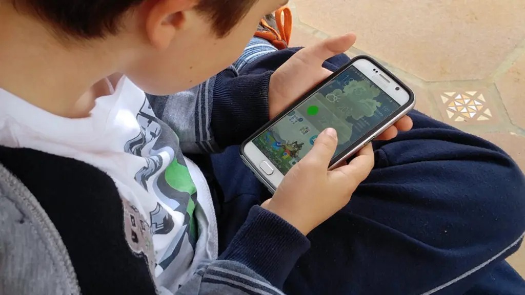 Niño sentado con un celular en sus manos