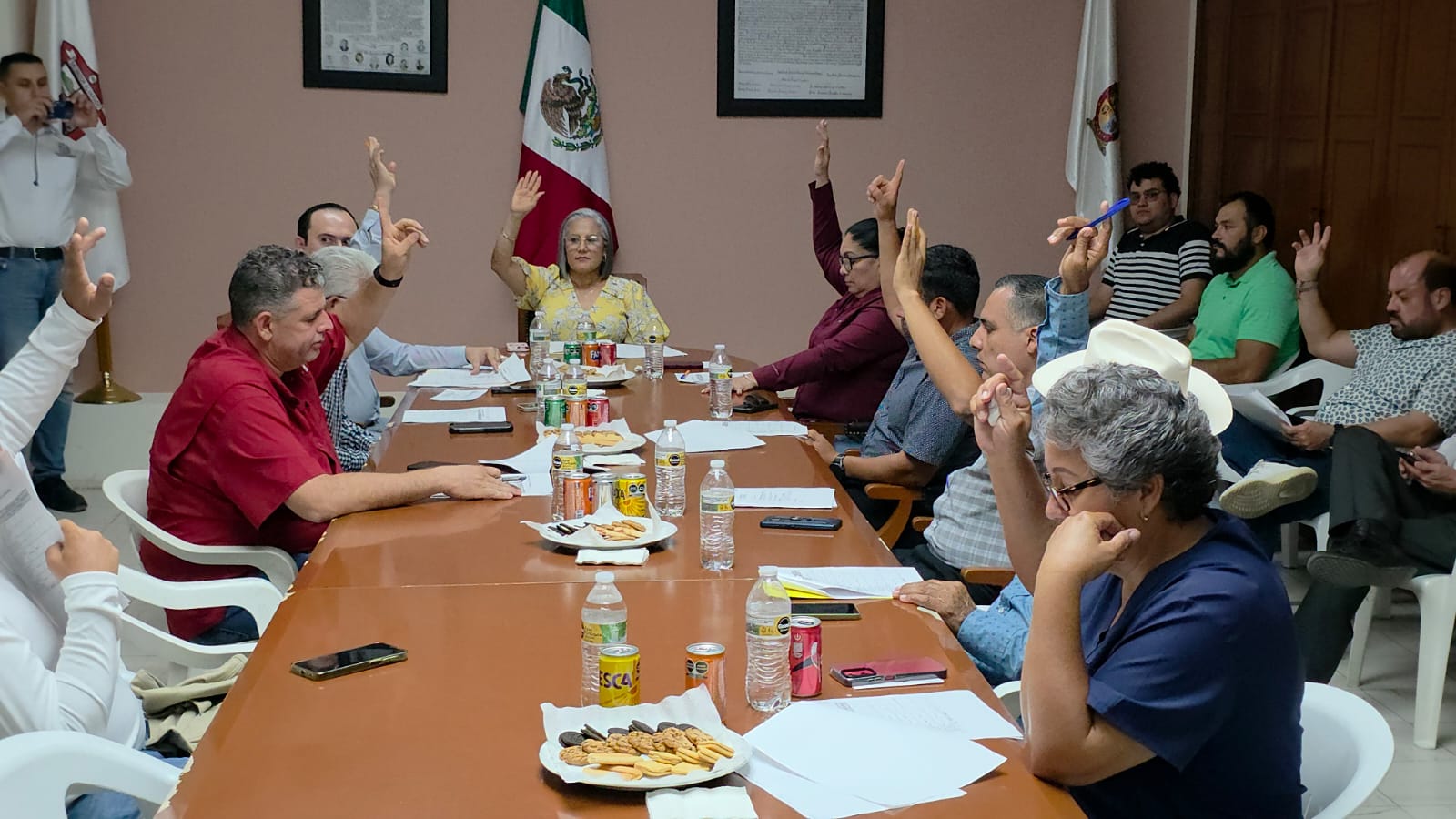 Autoridades de Salvador Alvarado en reunión, sentados en una mesa levantando la mano a manera de votación