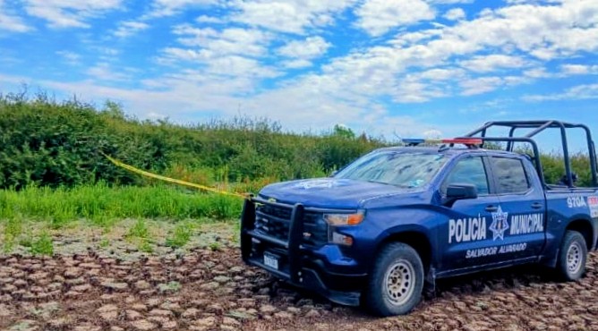Tierras junto a una camioneta de la policía y cinta amarilla de precaución