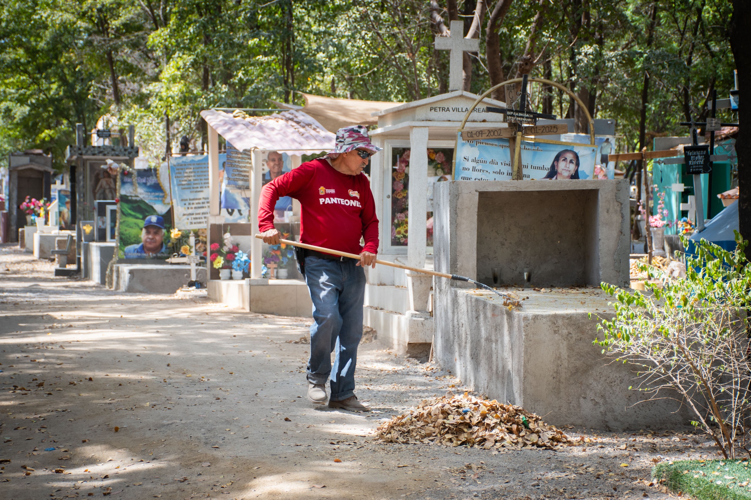 Elemento de obras publicas realizando limpieza en panteón