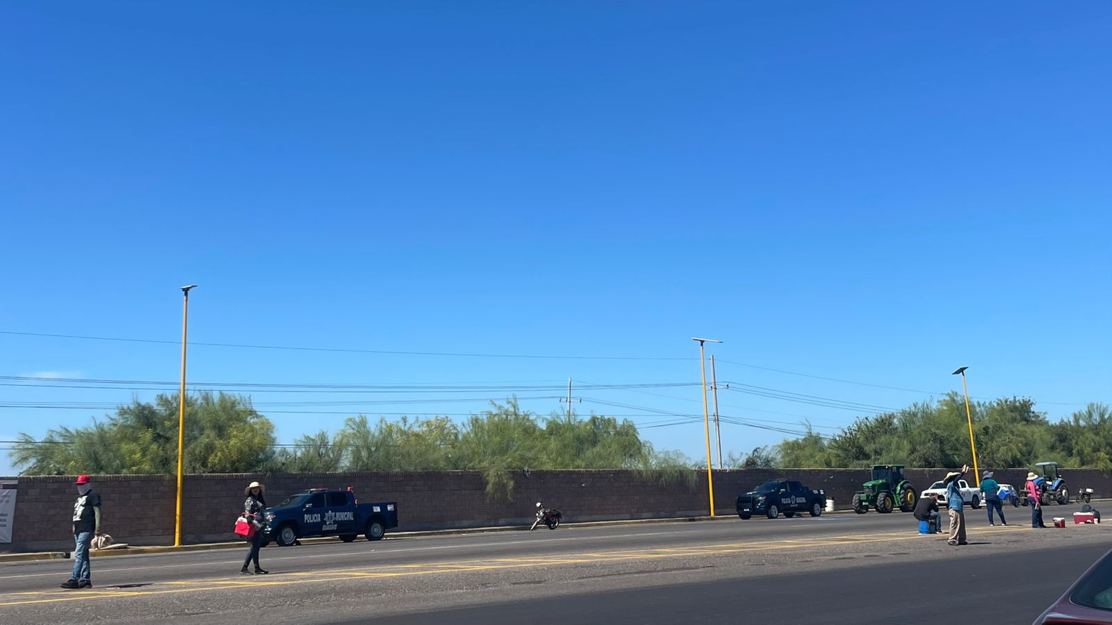 carros, patrullas, y tractores en paro en carretera