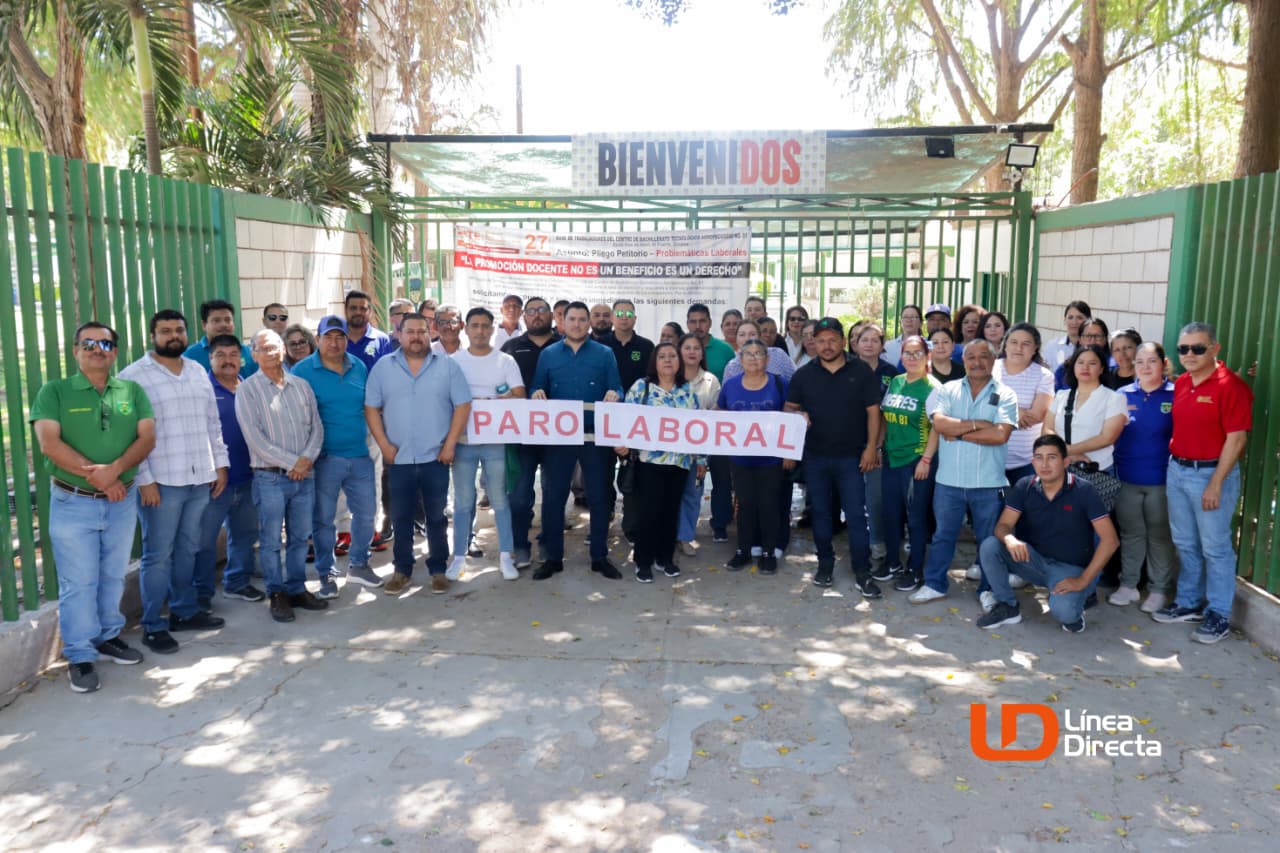 Personas a las afueras de una institución educativa a manera de protesta