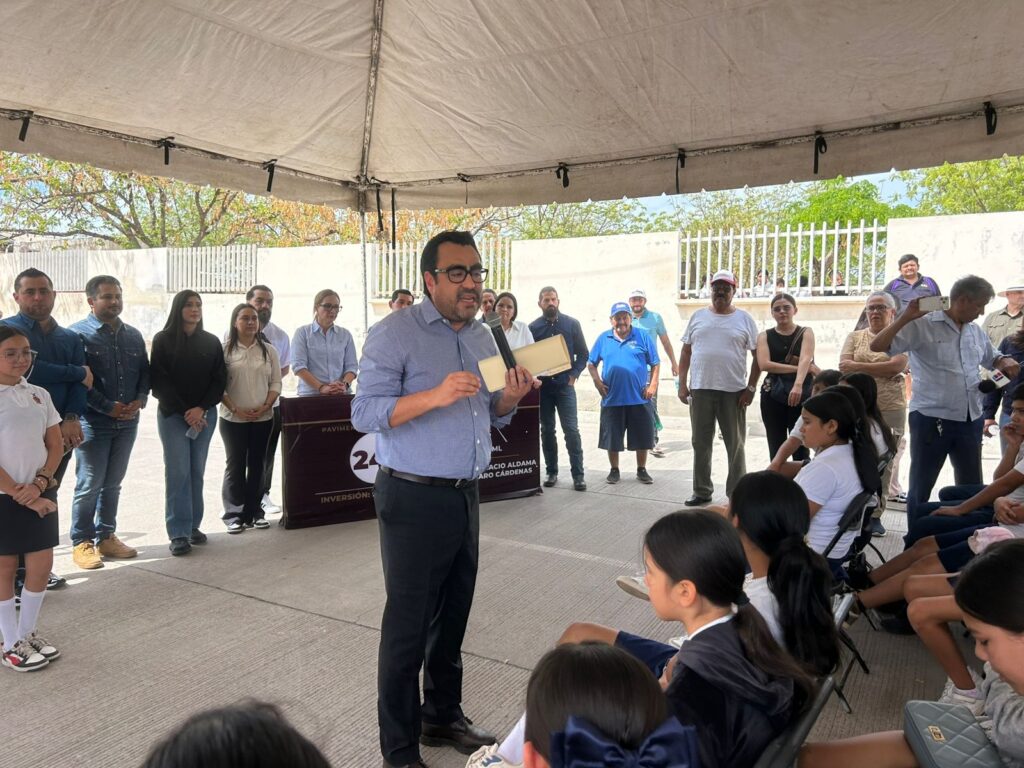 Alcalde de Culiacán con un micrófono debajo de una carpa blanca con personas reunidas