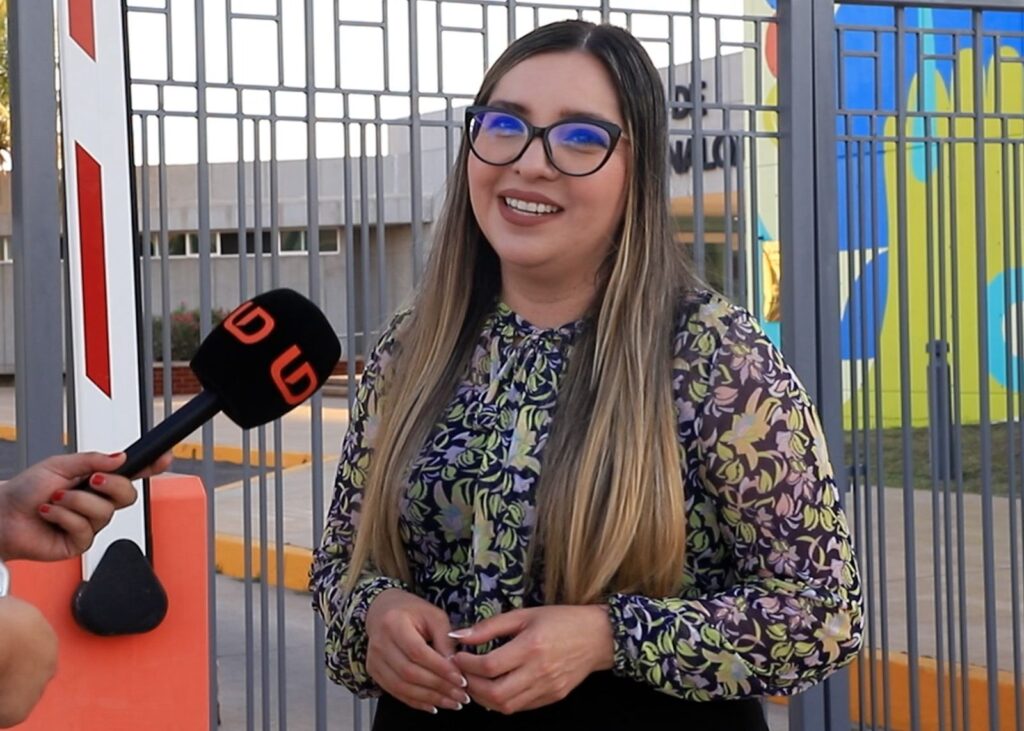 Mujer sonriendo junto a un micrófono negro con las letras LD de color naranja