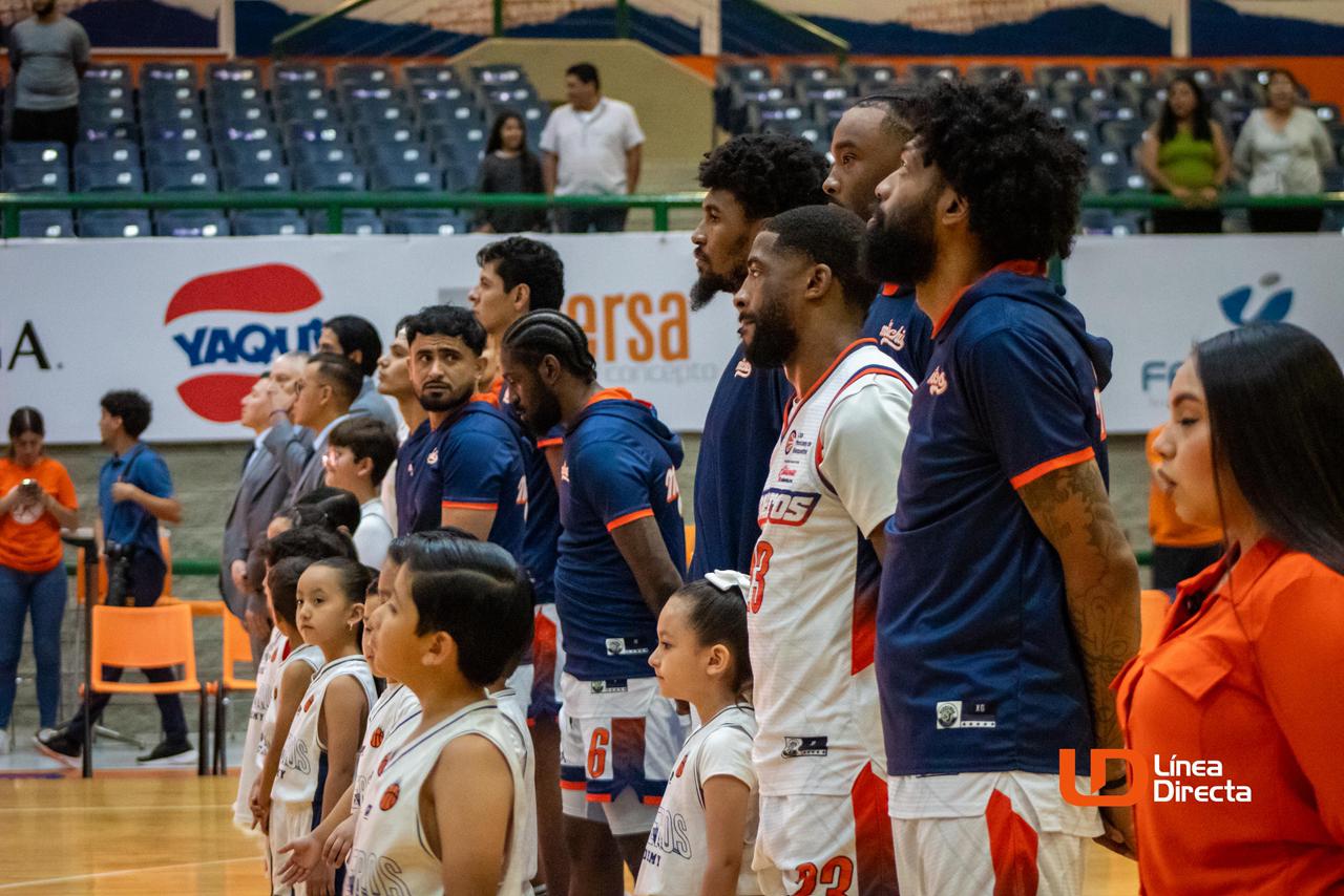 Jugadores de basquetbol en un partido en un auditorio