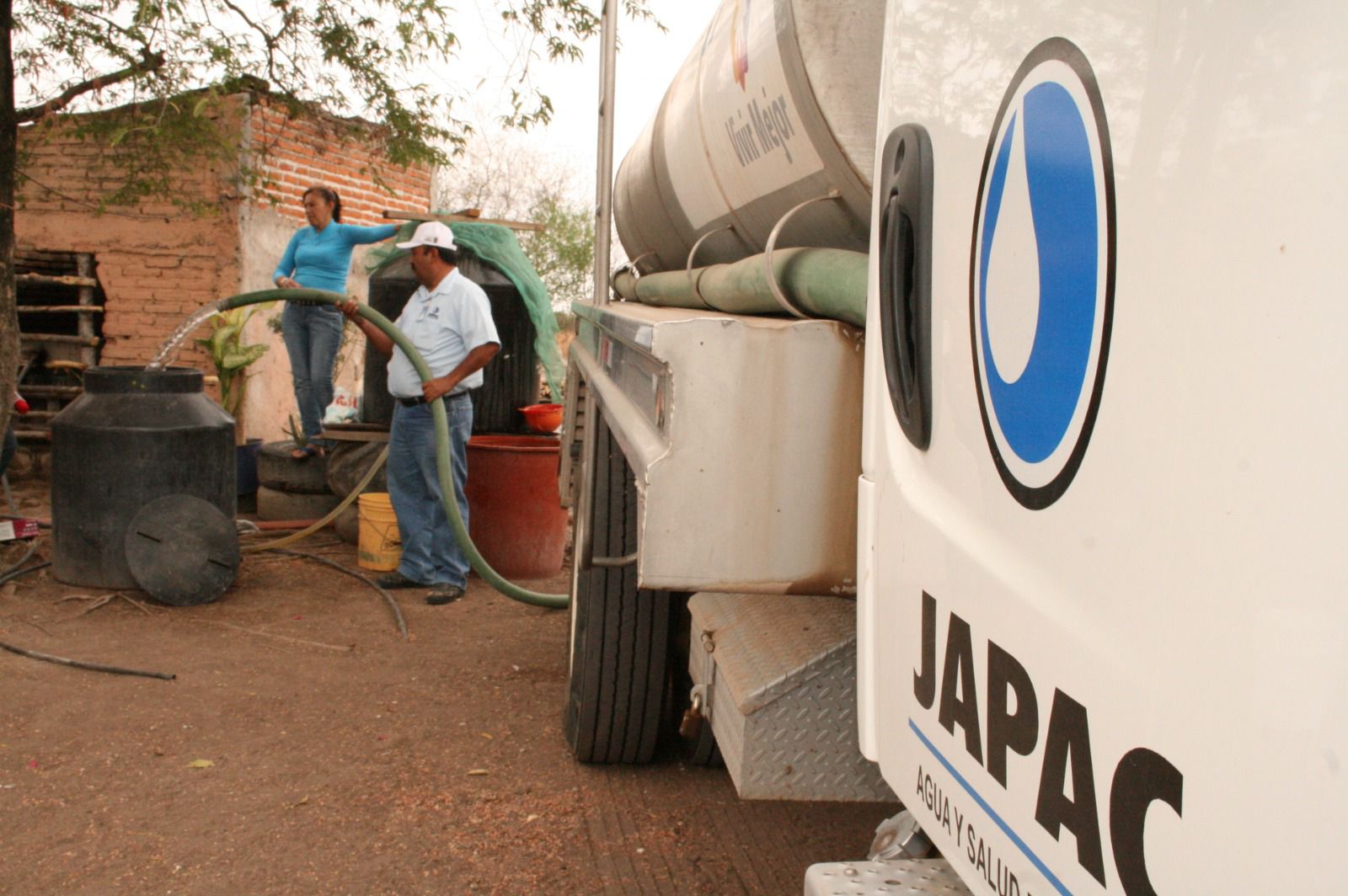 Trabajador de Japac vacía agua a contenedores de familias en comunidades rurales de Culiacán