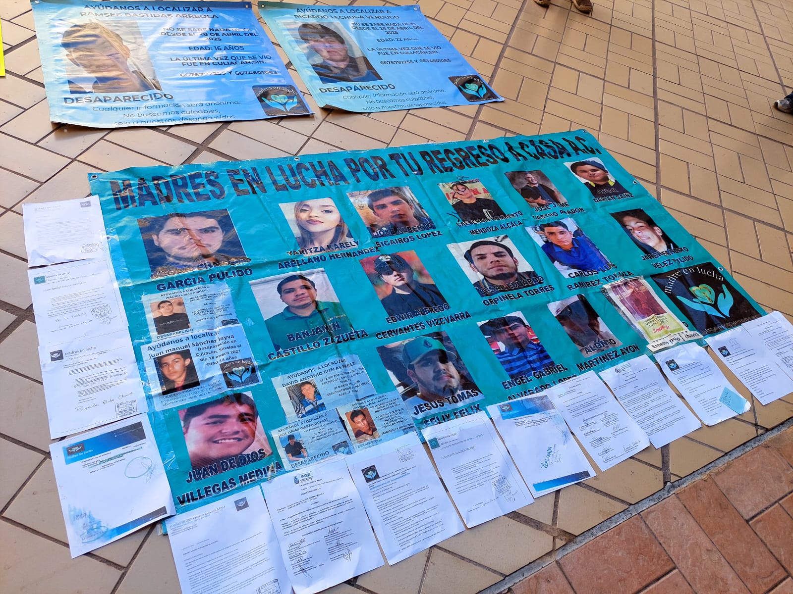 Fotografías de personas desaparecidas en una pancarta