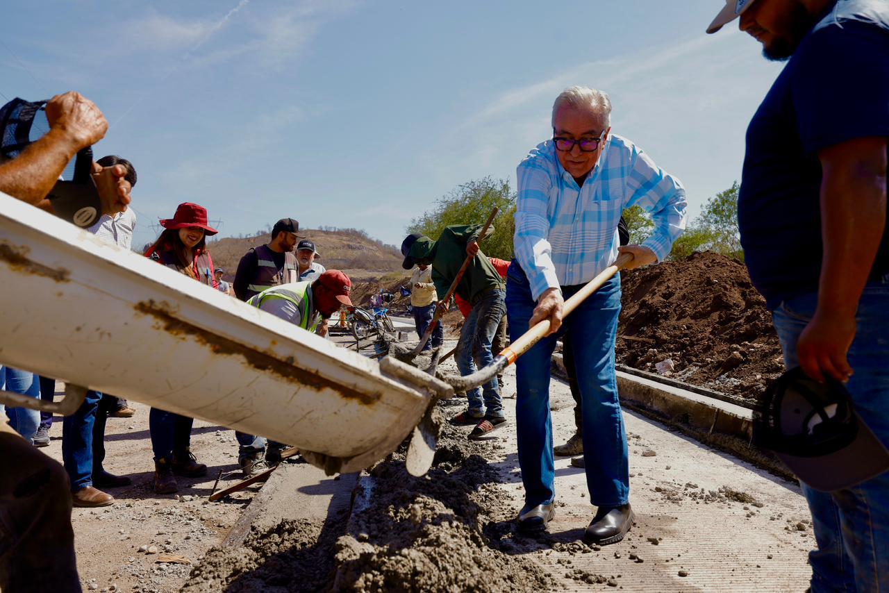Gobernador Rubén Rocha Moya con una pala junto a trabajadores y una máquina de cemento